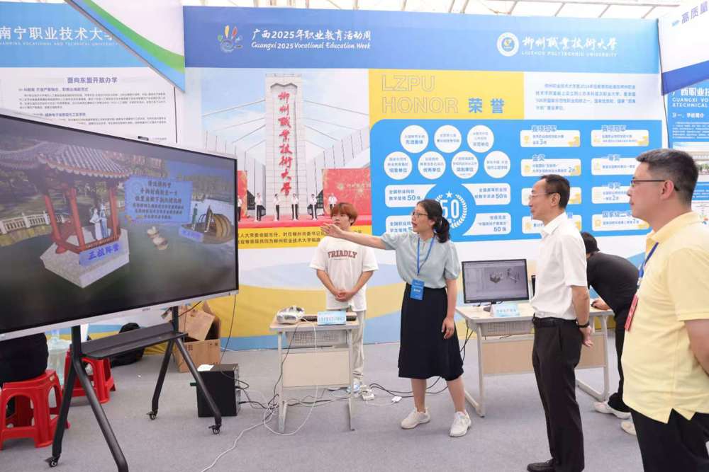 米乐官网教师向党委书记刘子林介绍壮族非遗文化VR新体验项目