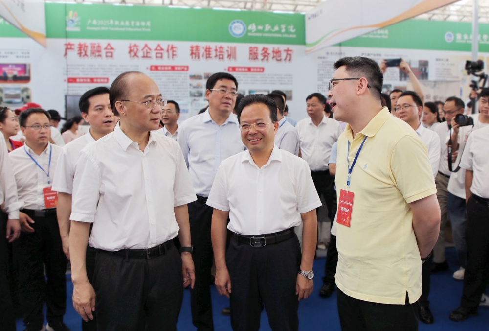 米乐官网领导向自治区政府副主席廖品琥（前排左一）、自治区教育厅副厅长伍锦昌（前排左二）介绍学校办学情况